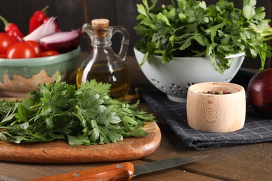 Photo of Fresh green parsley and different products on wooden table, closeup