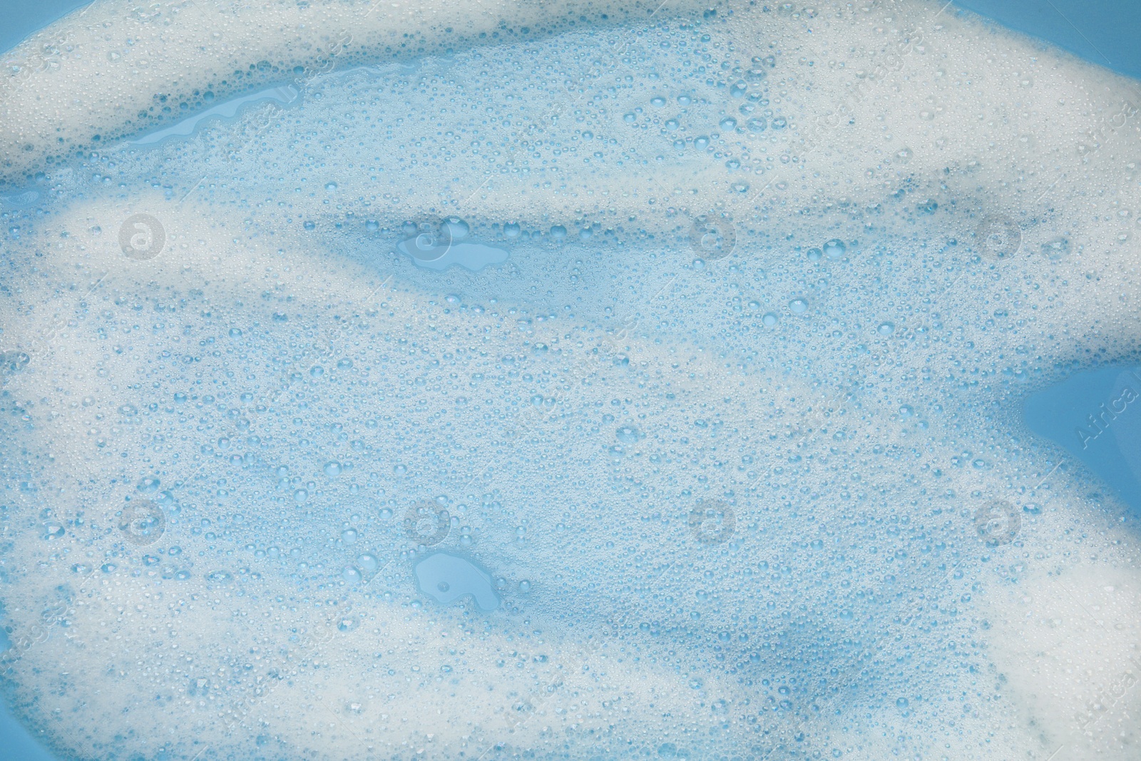 Photo of White washing foam on color background, top view