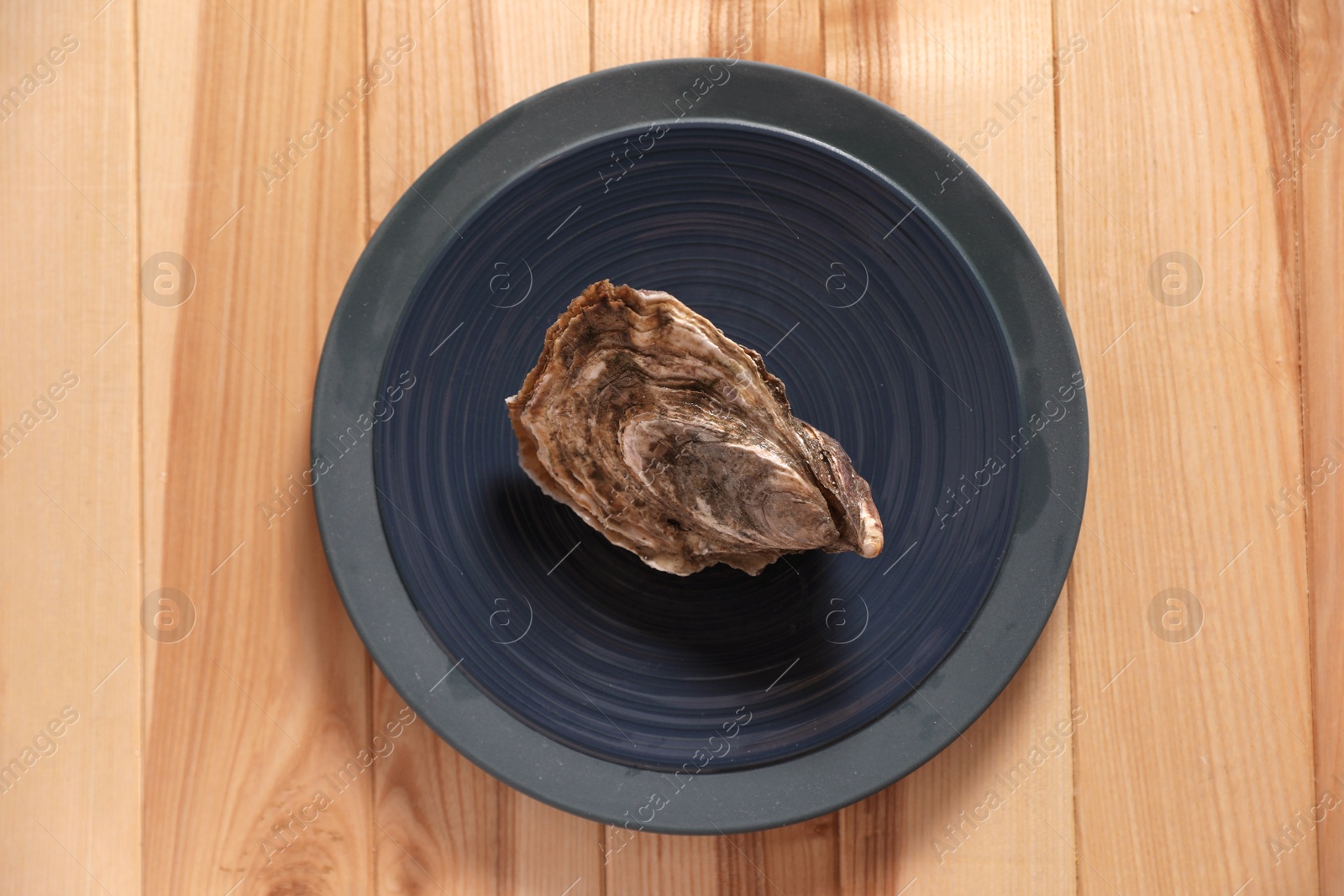 Photo of Fresh oyster on wooden table, top view