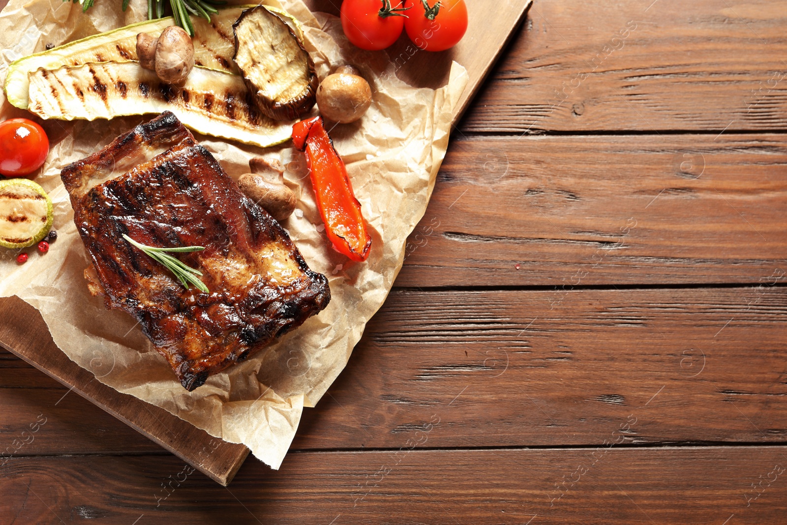 Photo of Flat lay composition with delicious barbecued meat on wooden background. Space for text