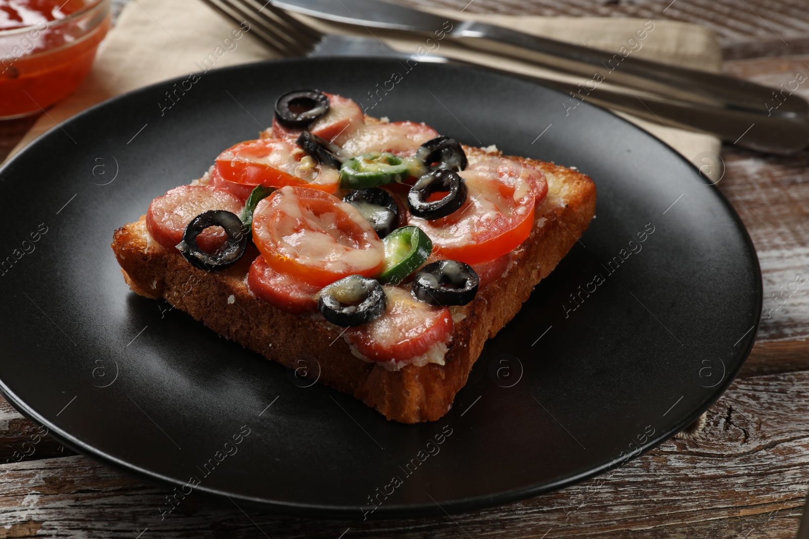 Photo of Tasty pizza toast and cutlery on wooden table, closeup