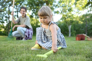 Mother and her daughter working together in garden