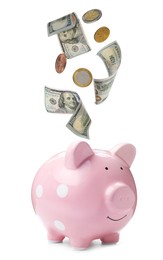 Image of Banknotes and coins falling into piggy bank on white background. Saving money