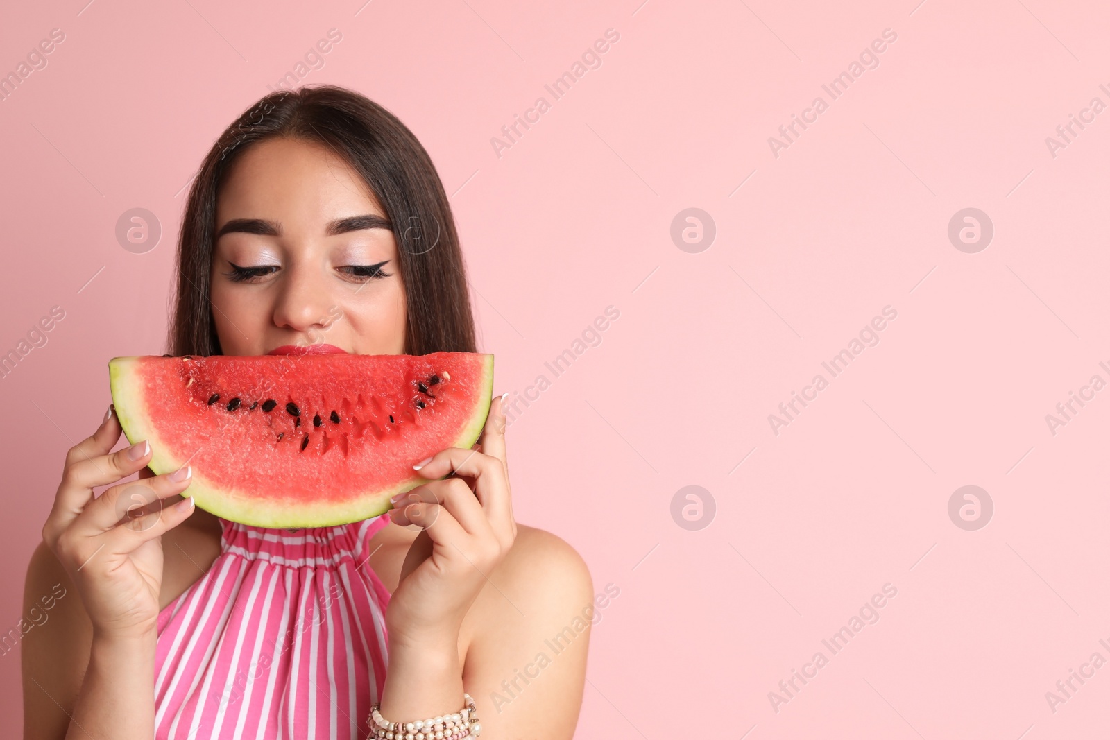 Photo of Beautiful young woman posing with watermelon on color background