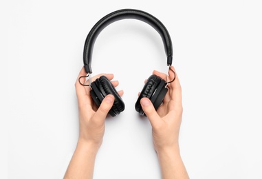 Woman holding stylish headphones on white background, closeup