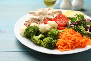 Photo of Balanced diet and healthy foods. Plate with different delicious products on blue wooden table, closeup