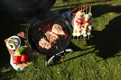 Photo of Cooking meat and vegetables on barbecue grill outdoors, flat lay. Space for text