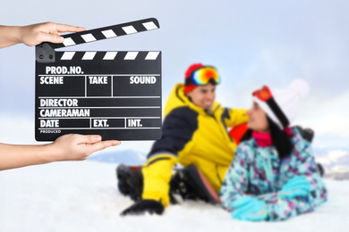 Image of Assistant holding clapperboard and people on snowy hill, closeup. Cinema production 