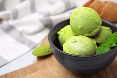 Photo of Tasty matcha ice cream in bowl on table, closeup. Space for text