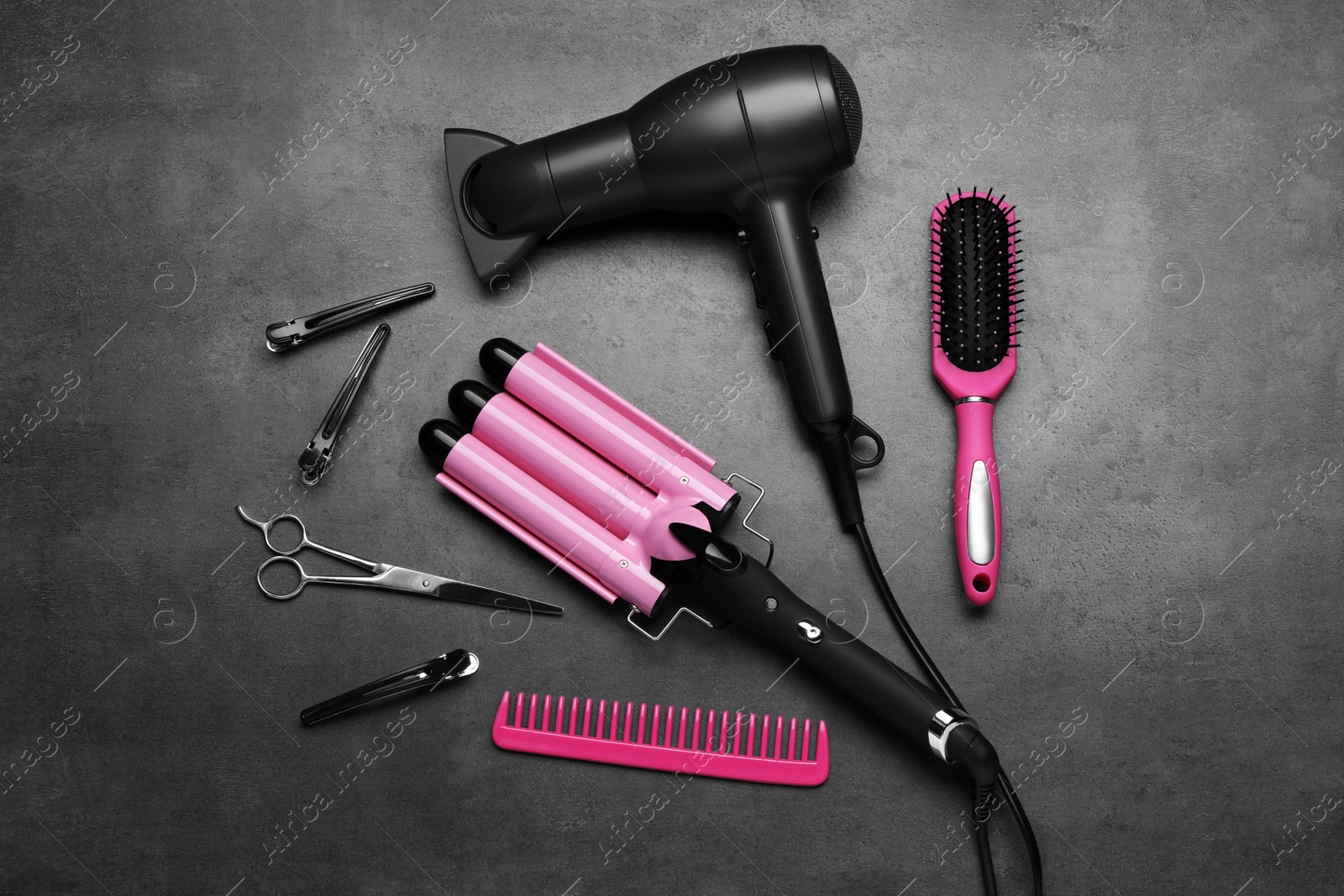 Photo of Flat lay composition of different professional hairdresser tools on dark grey table