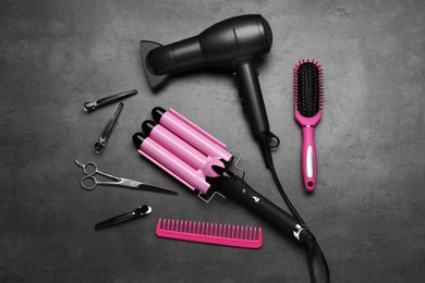 Photo of Flat lay composition of different professional hairdresser tools on dark grey table