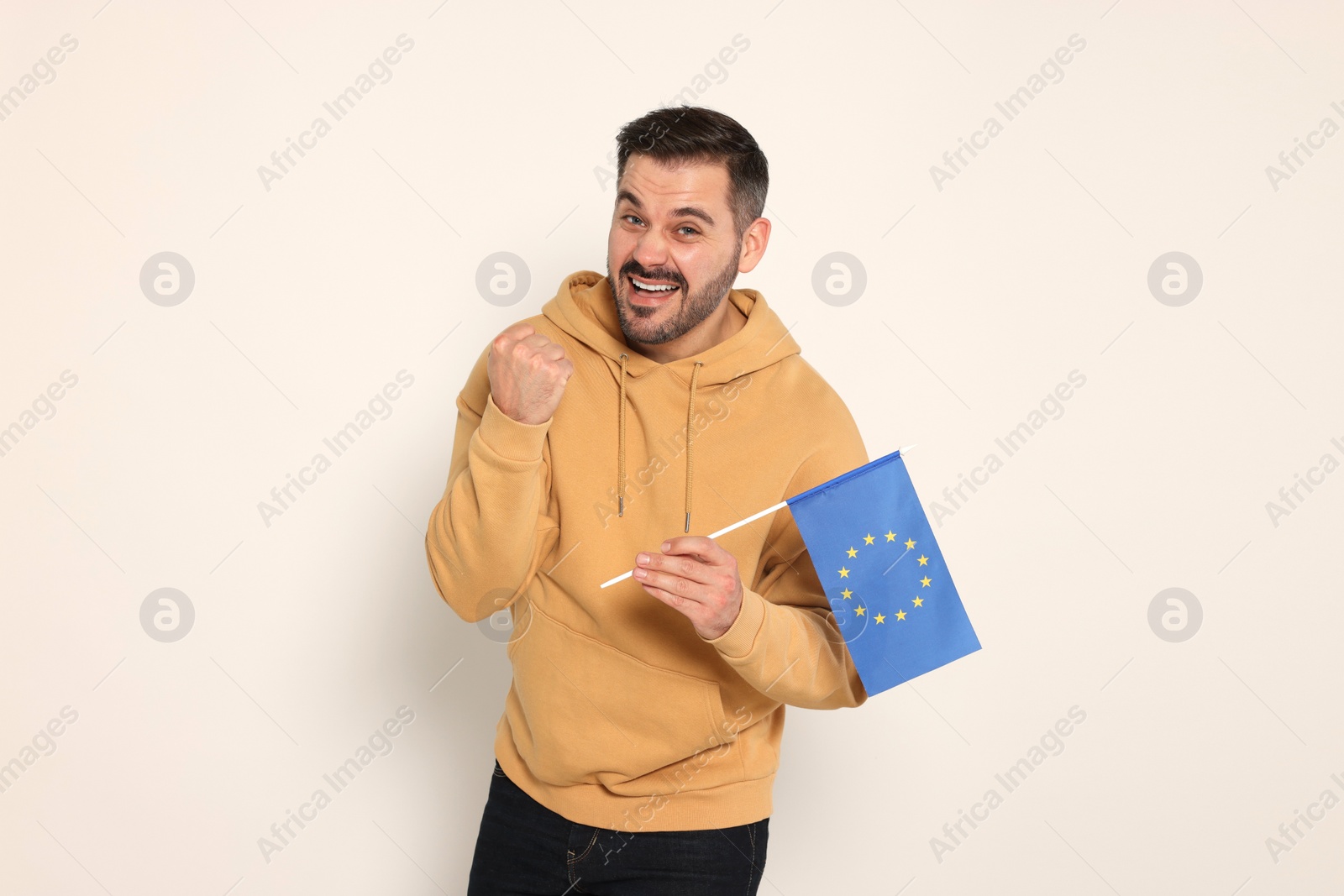 Photo of Emotional man with flag of European Union on white background