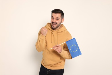 Emotional man with flag of European Union on white background