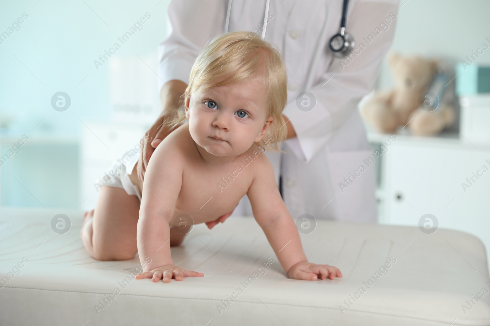 Photo of Pediatrician examining baby in hospital. Health care
