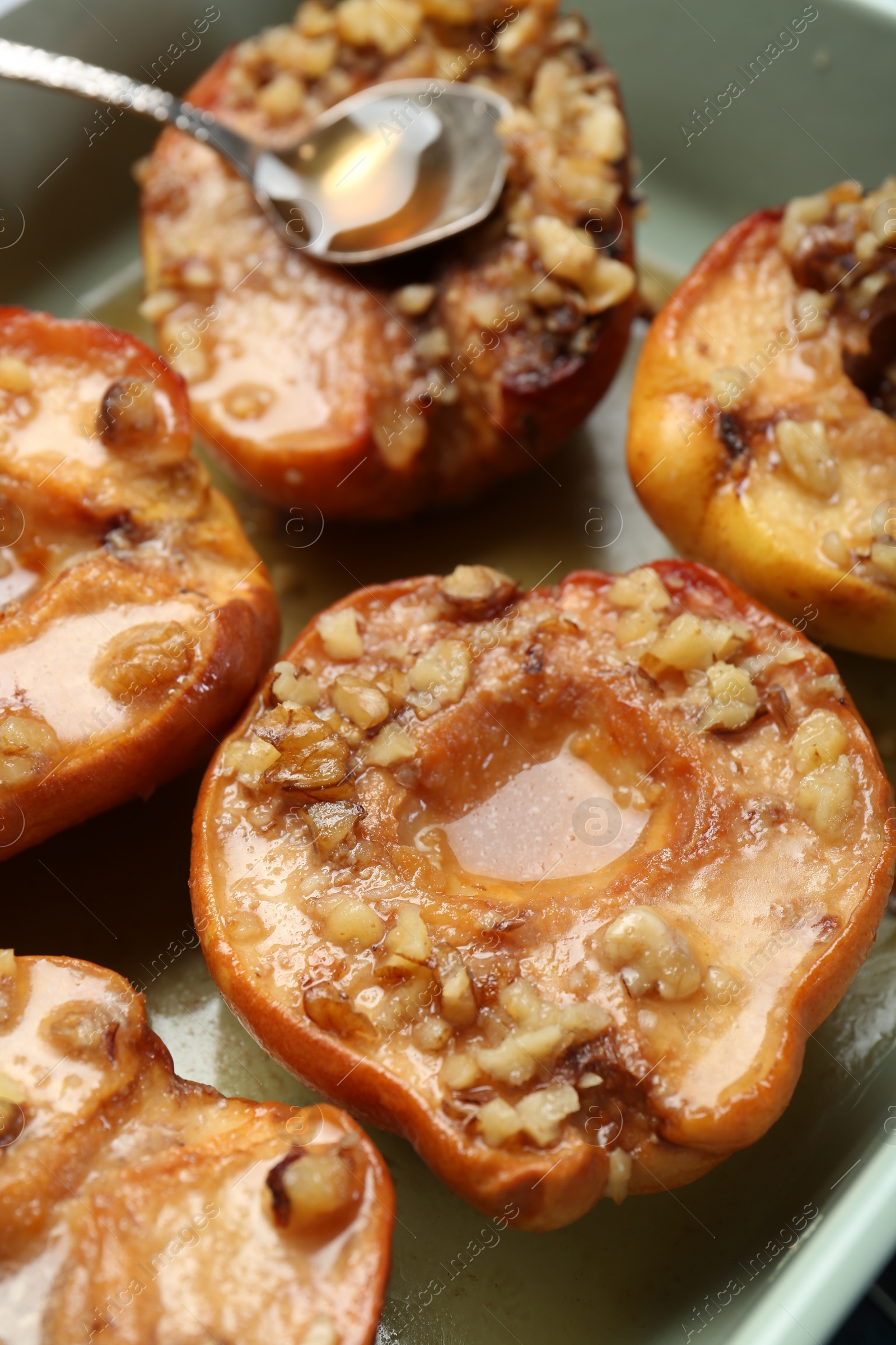 Photo of Tasty baked quinces with nuts and honey in dish, closeup
