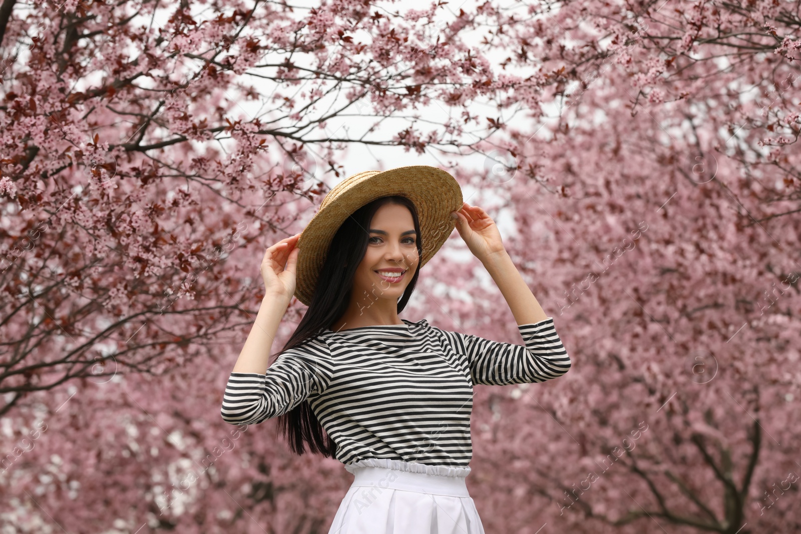 Photo of Pretty young woman in park with blooming trees. Spring look