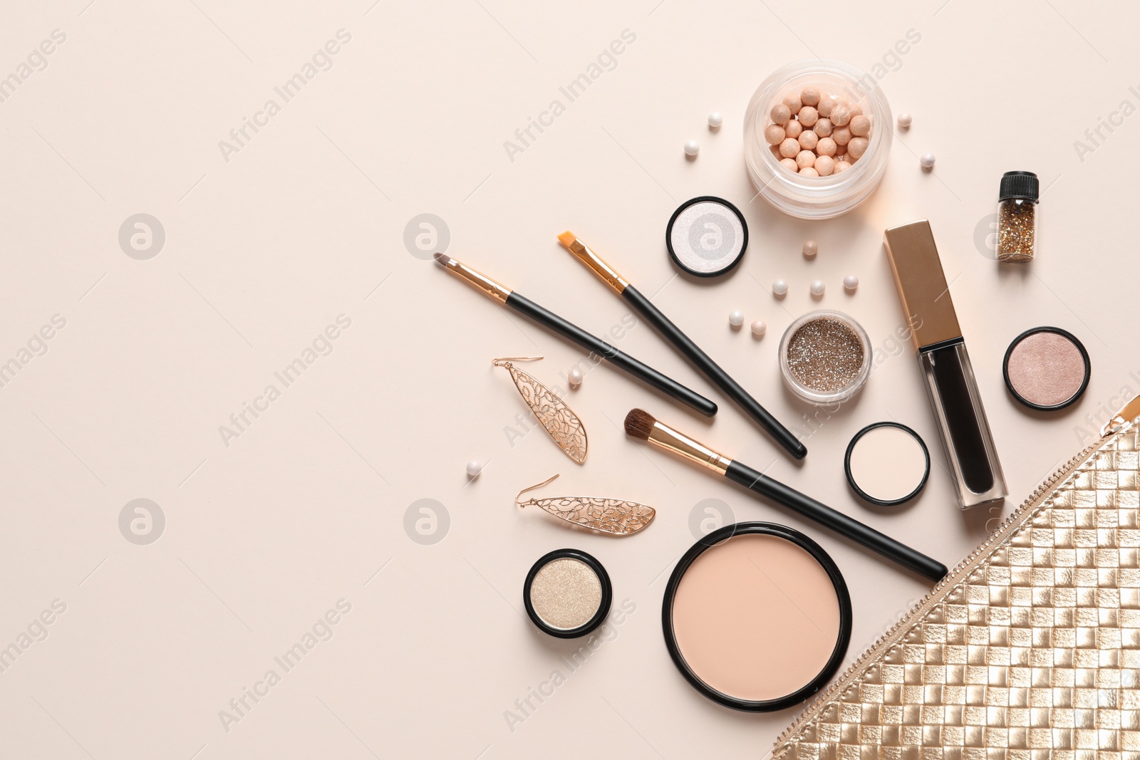 Photo of Cosmetic bag and different luxury makeup products on color background, flat lay. Space for text