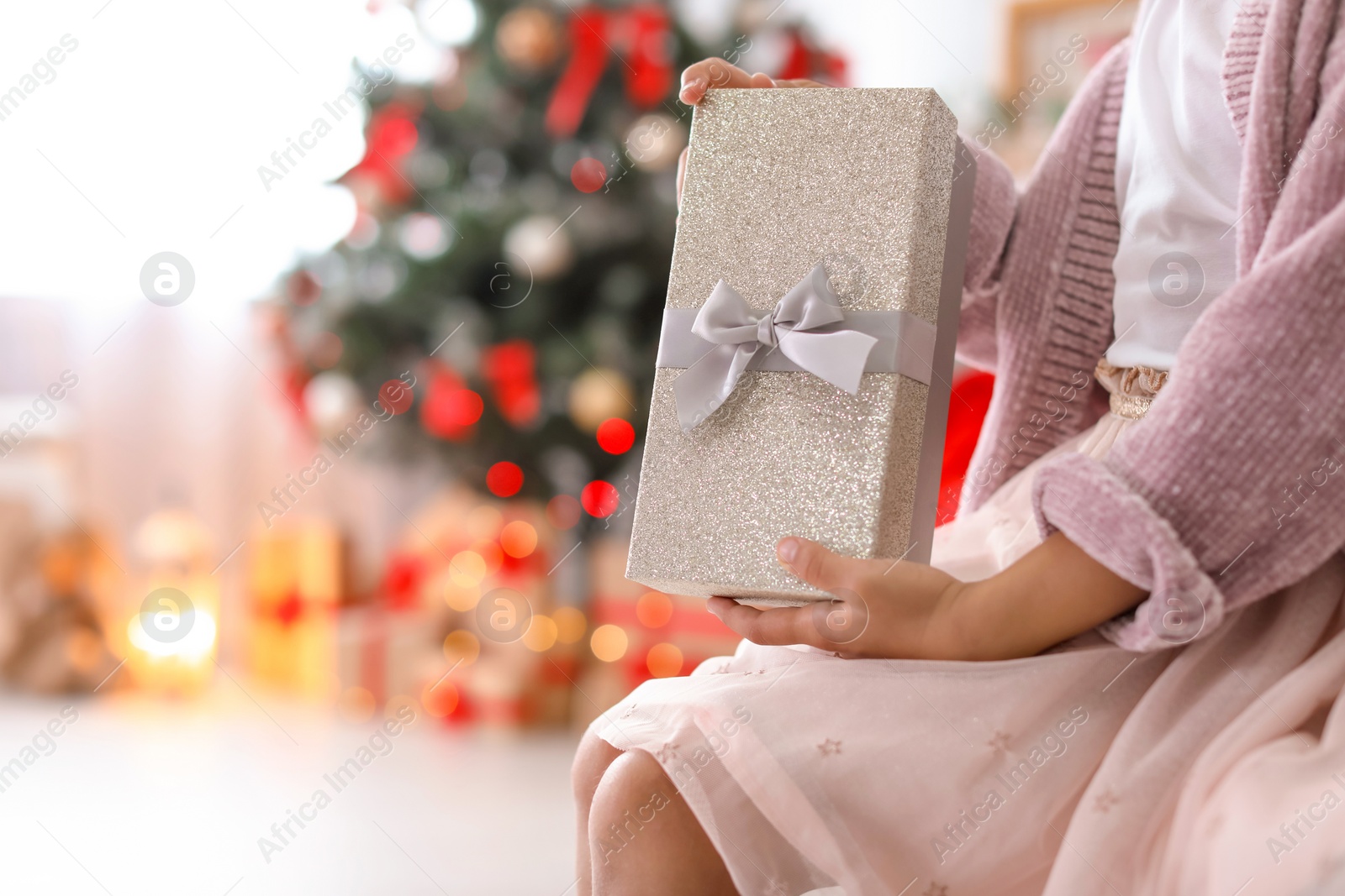 Photo of Cute little child with Christmas gift box at home