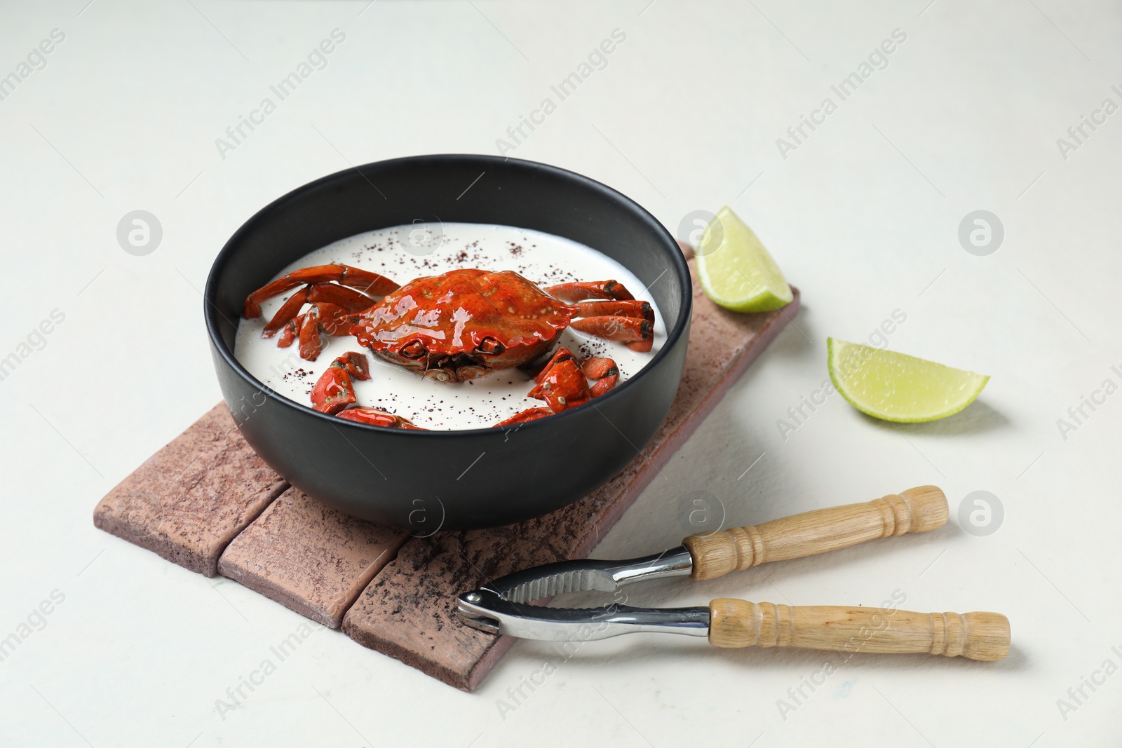 Photo of Delicious boiled crab with cream sauce and lime served on white table