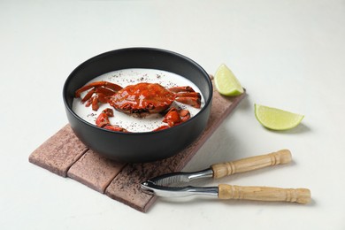 Photo of Delicious boiled crab with cream sauce and lime served on white table