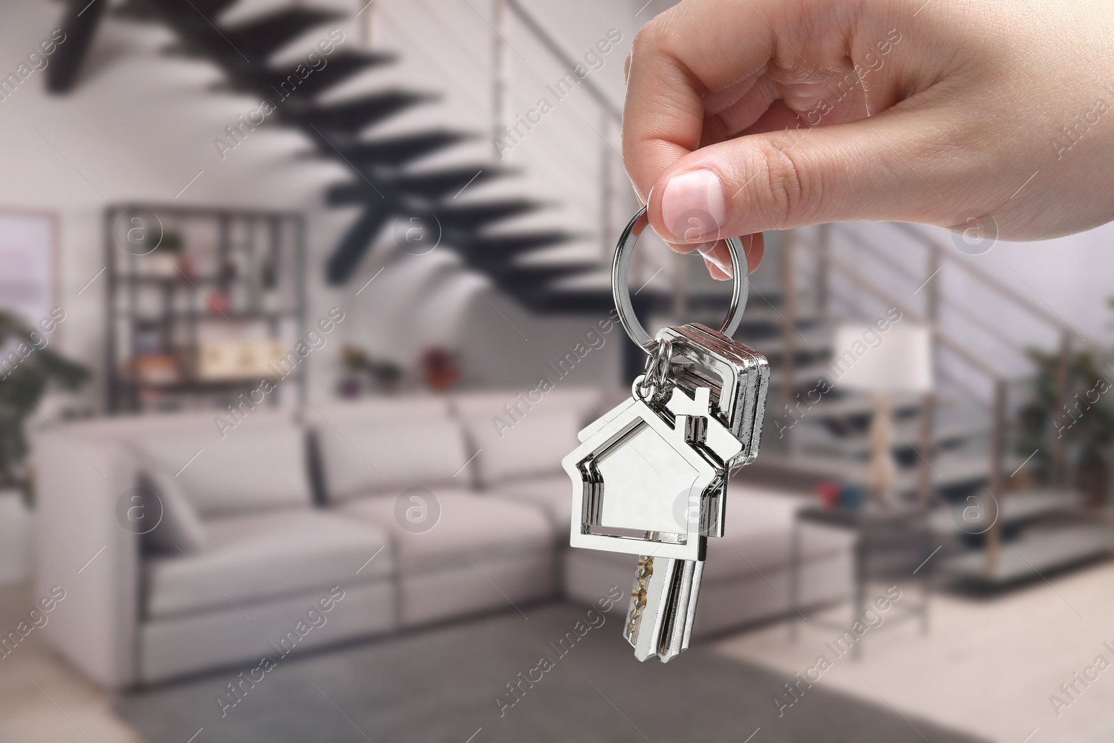 Image of Woman holding house keys in room, closeup