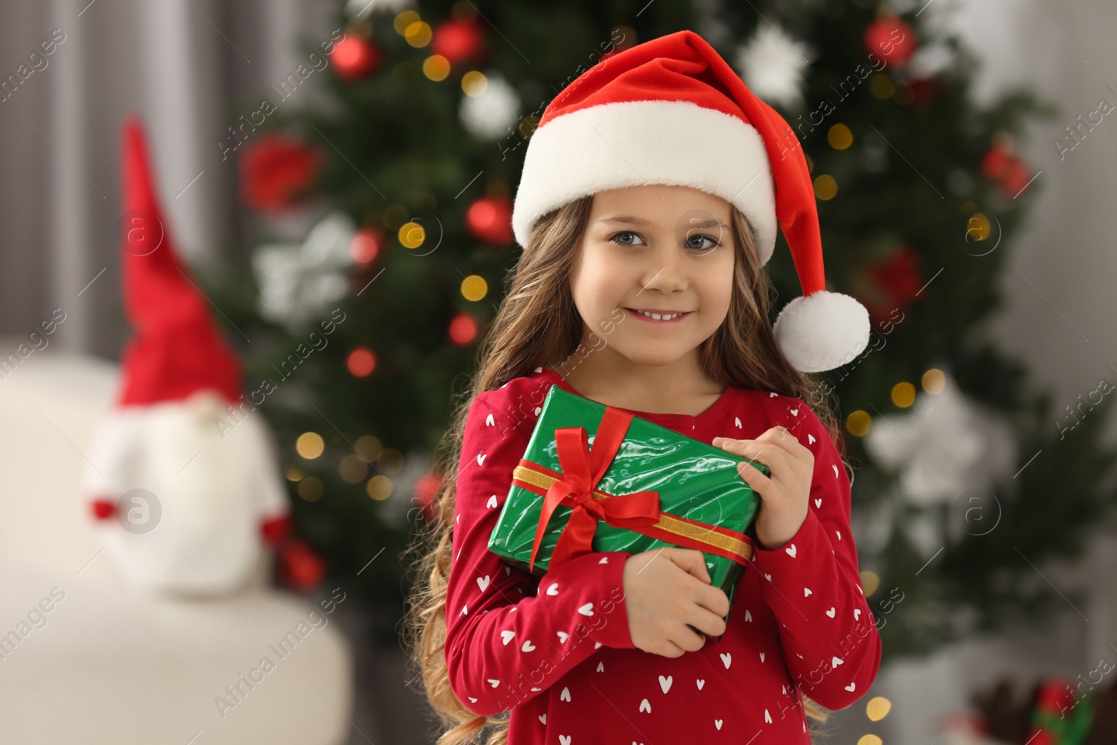 Photo of Happy girl with Christmas gift at home. Space for text