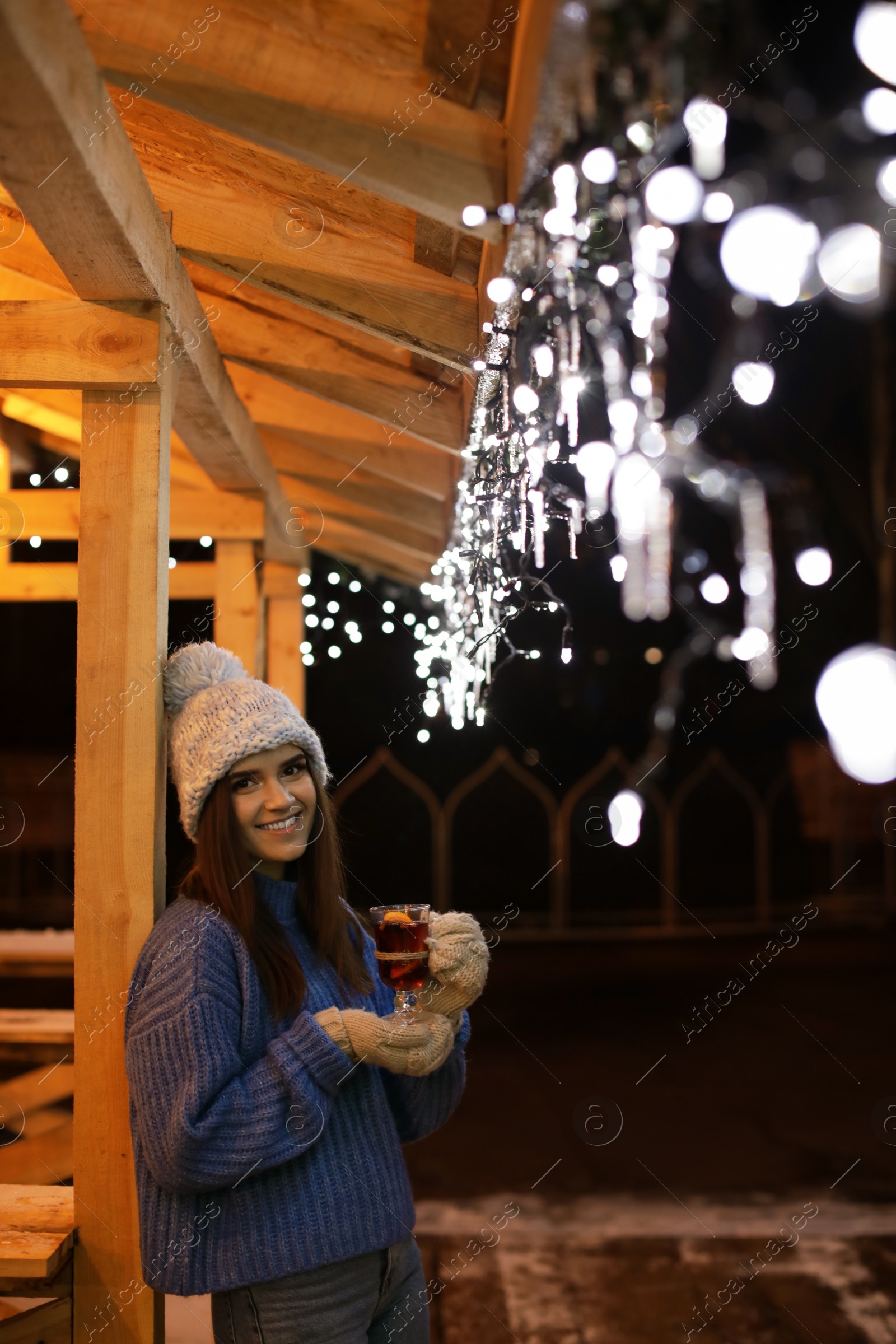 Photo of Woman with glass cup of mulled wine at winter fair