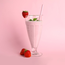 Tasty fresh milk shake and strawberries on pink background