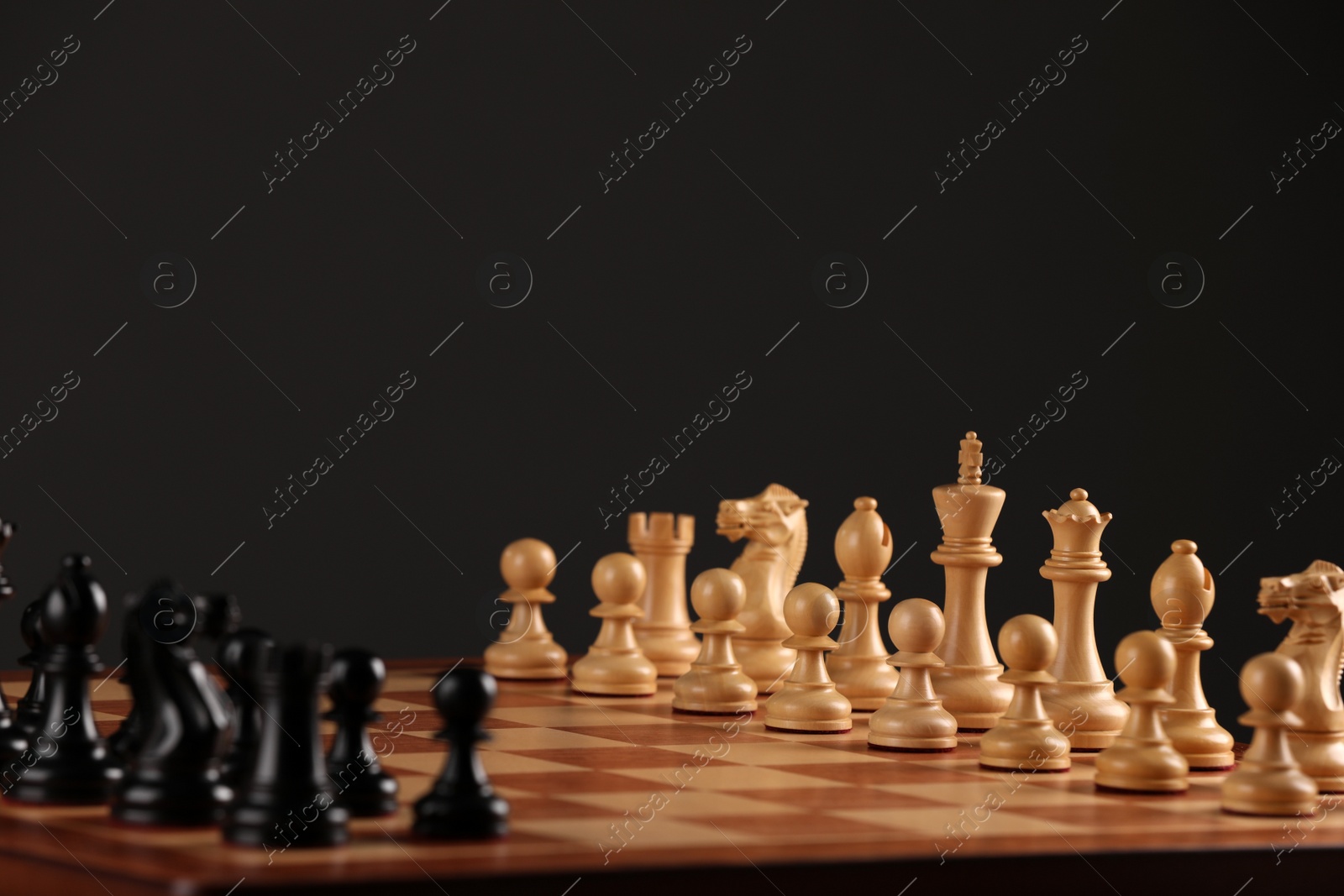 Photo of Chessboard with game pieces on black background