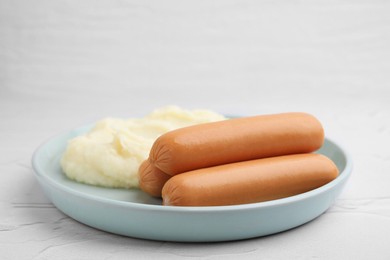 Photo of Delicious boiled sausages and mashed potato on white textured table, closeup