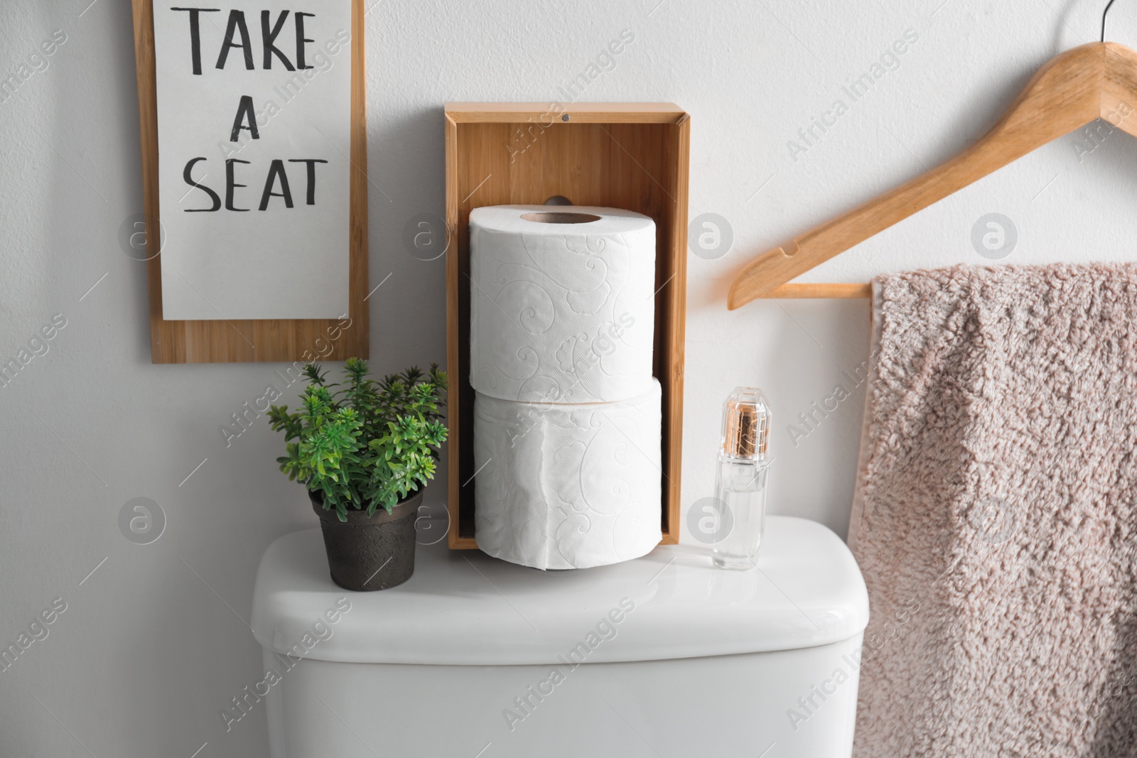 Photo of Decor elements, necessities and toilet bowl near white wall. Bathroom interior