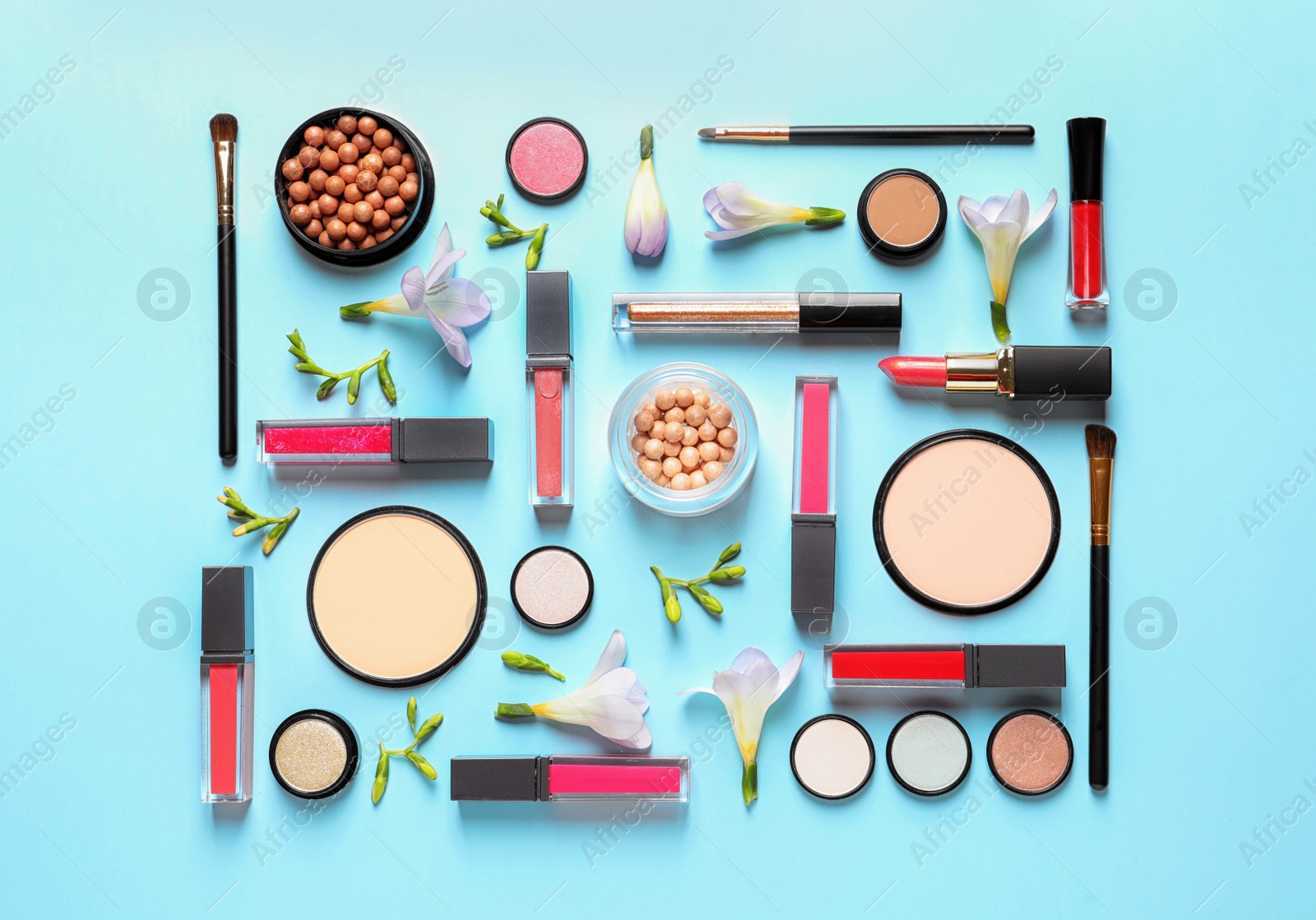 Photo of Makeup products and flowers on color background, flat lay