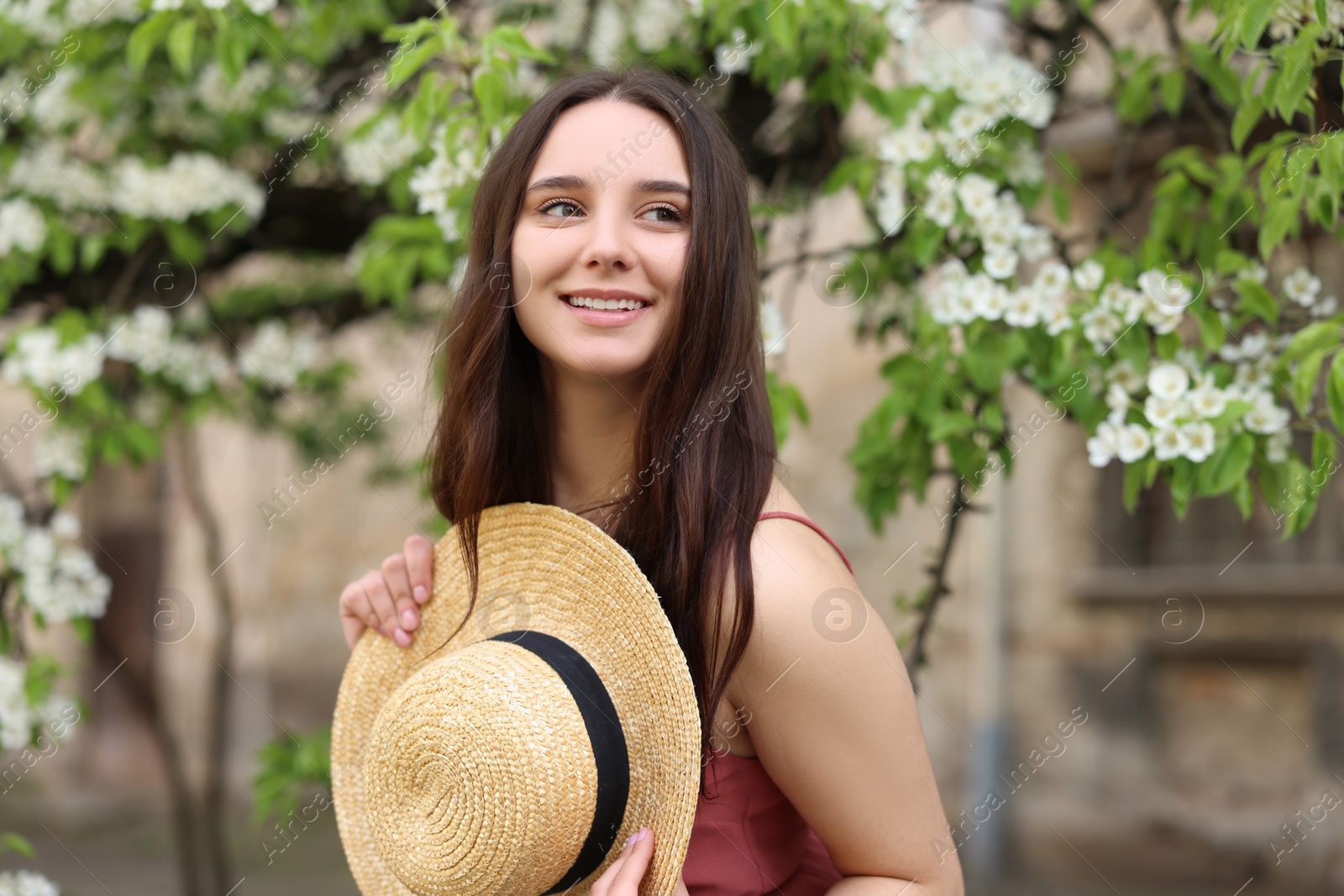 Photo of Beautiful woman with straw hat near blossoming tree on spring day