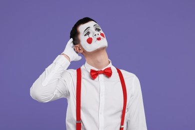 Photo of Mime artist making sad face on purple background