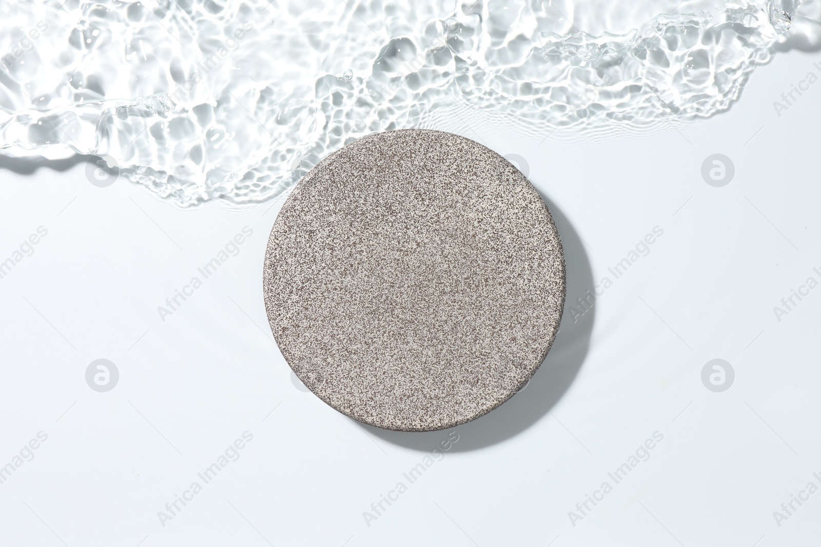 Photo of Presentation for product. Stone podium in water on white background, top view