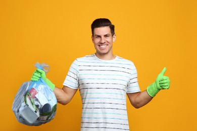 Photo of Man holding full garbage bag on yellow background