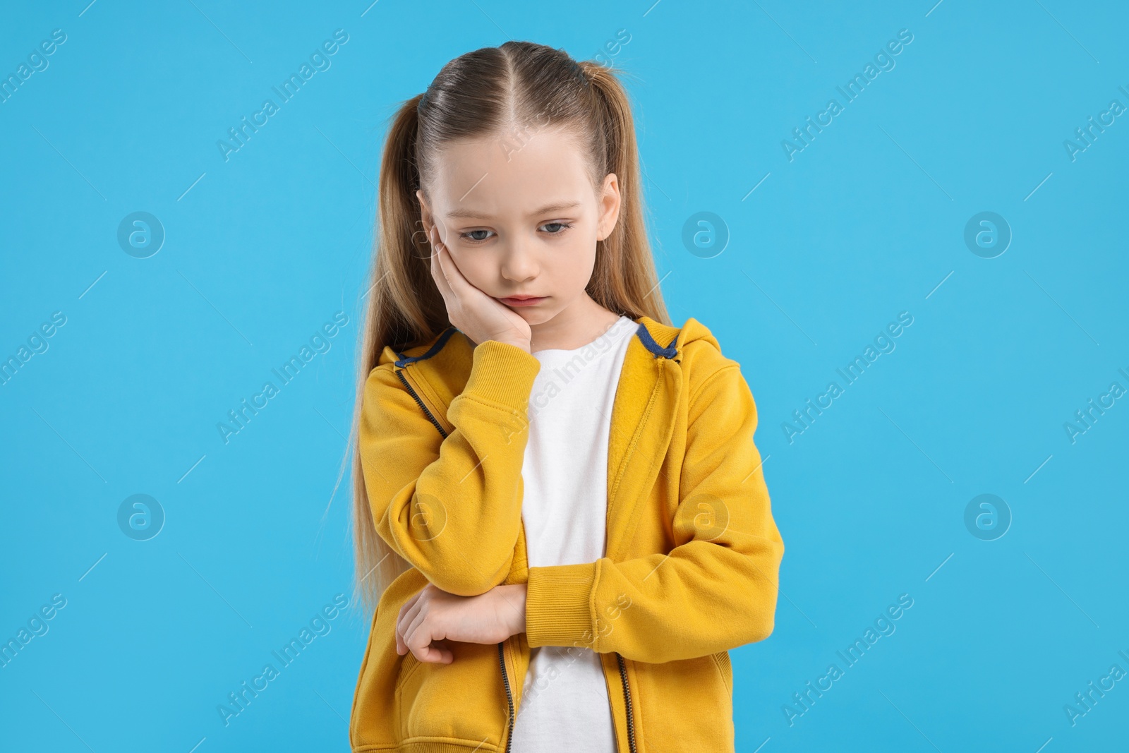 Photo of Portrait of sad girl on light blue background