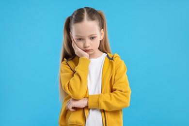 Photo of Portrait of sad girl on light blue background
