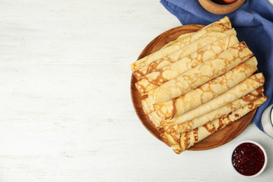 Photo of Flat lay composition with fresh thin pancakes on white wooden table. Space for text