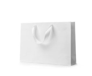 Photo of Paper shopping bag with ribbon handles on white background. Mockup for design