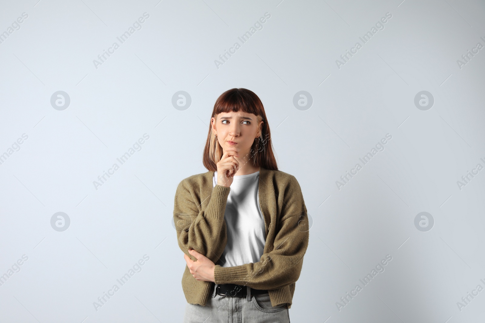 Photo of Portrait of confused young girl on white background