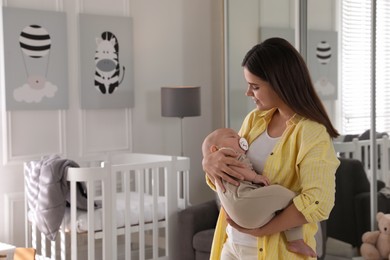 Photo of Young woman with her sleeping baby at home