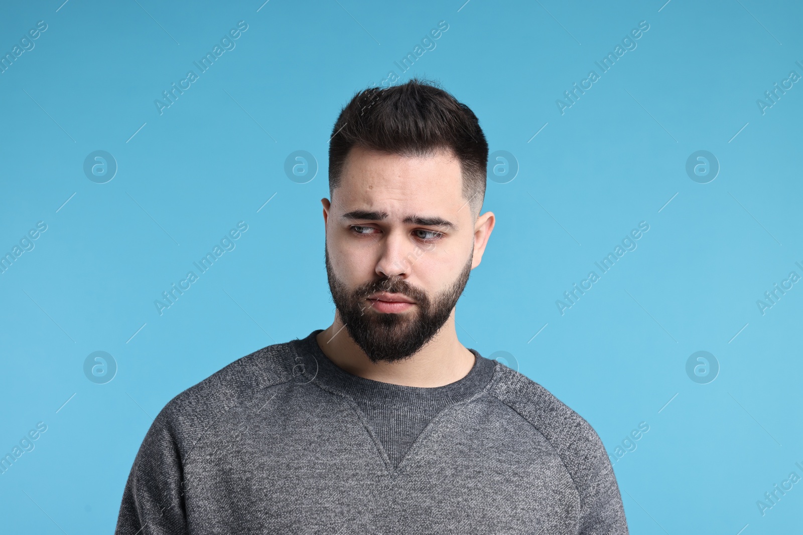 Photo of Portrait of sad man on light blue background