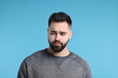 Photo of Portrait of sad man on light blue background