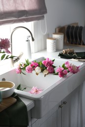 Photo of Bunch of beautiful peonies in kitchen sink