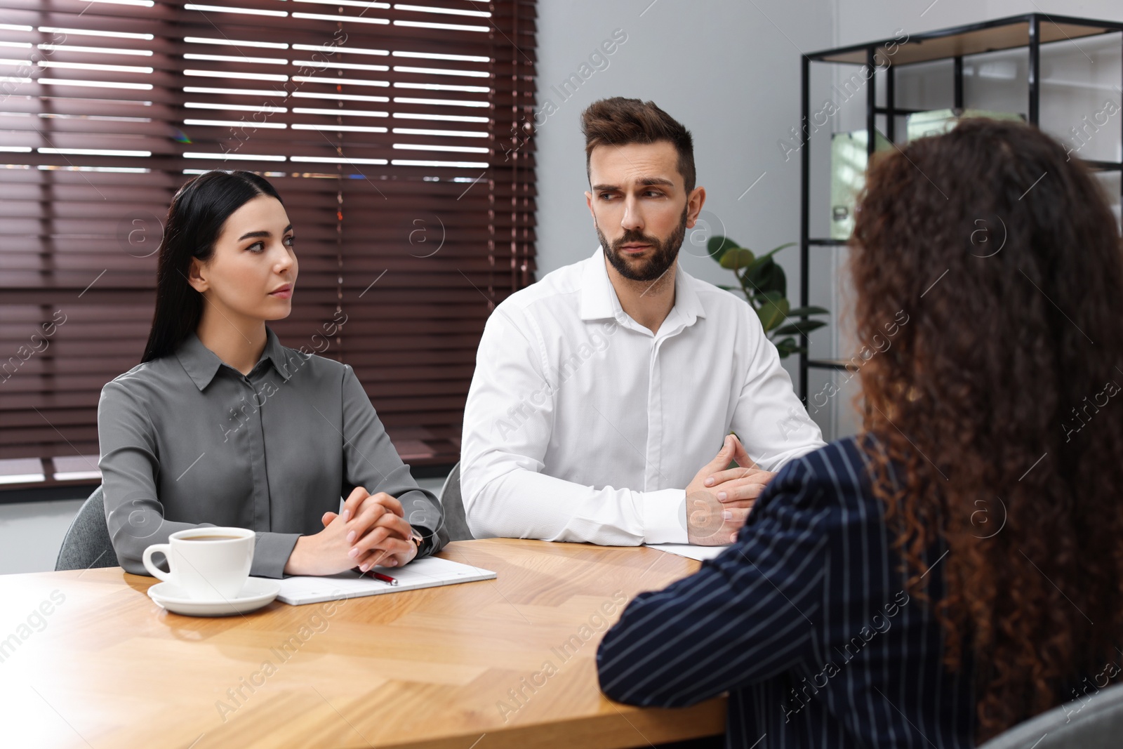 Photo of Coworkers conducting job interview with African American woman in office. Racism concept