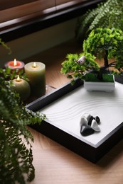 Photo of Beautiful miniature zen garden and candles on table
