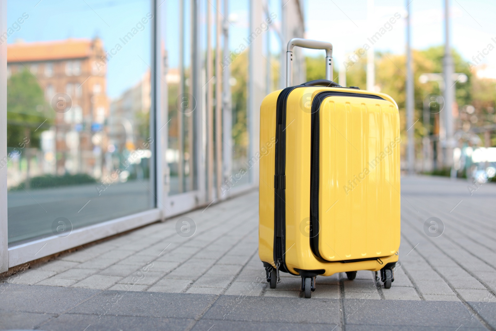 Photo of Packed yellow carry on suitcase on city street