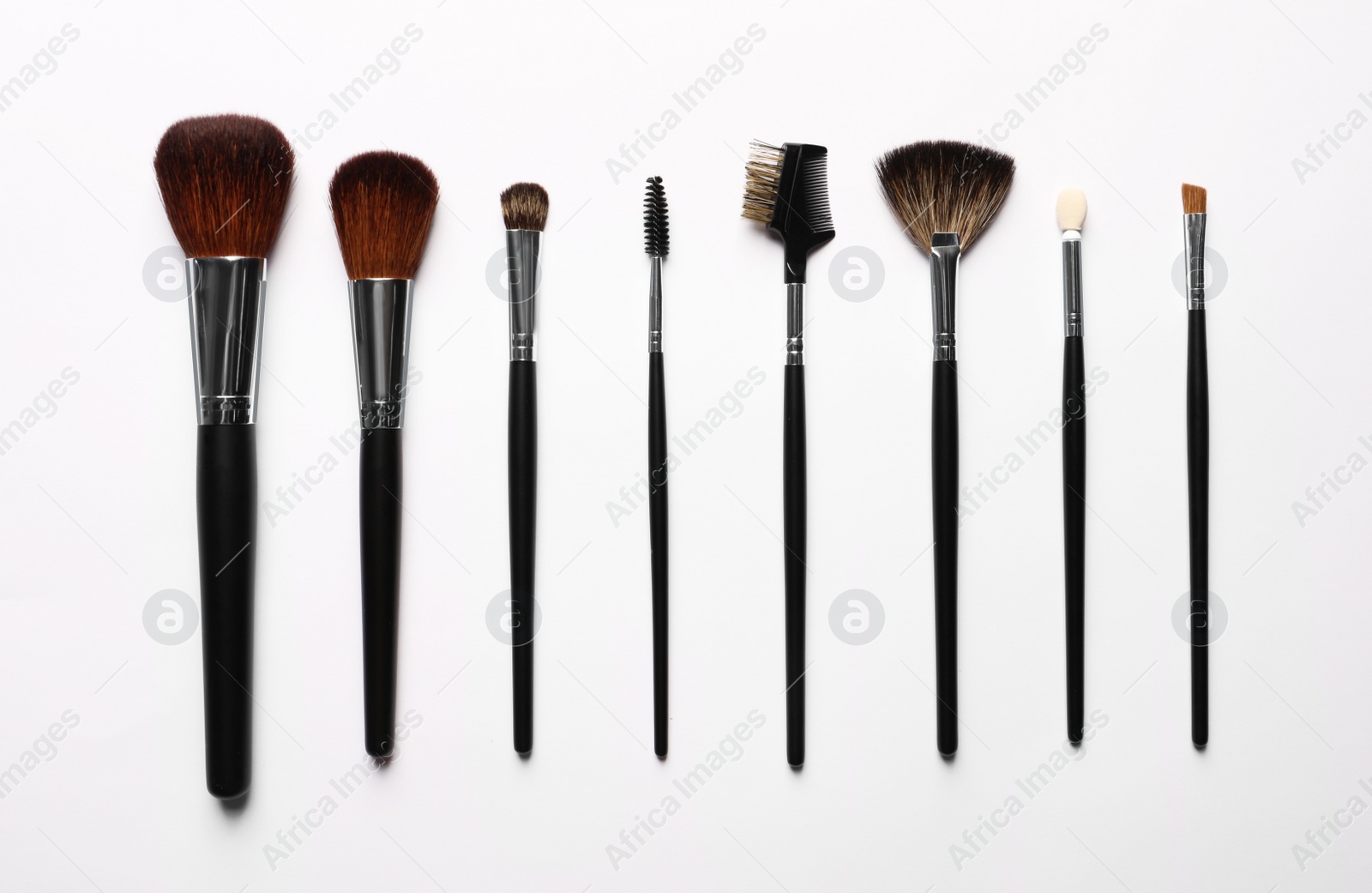 Photo of Different makeup brushes on white background, flat lay