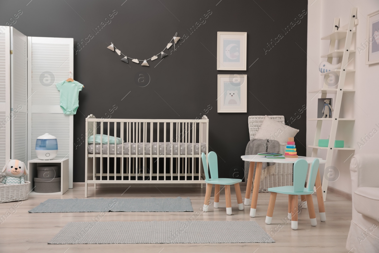 Photo of Cute baby room interior with modern crib near dark wall